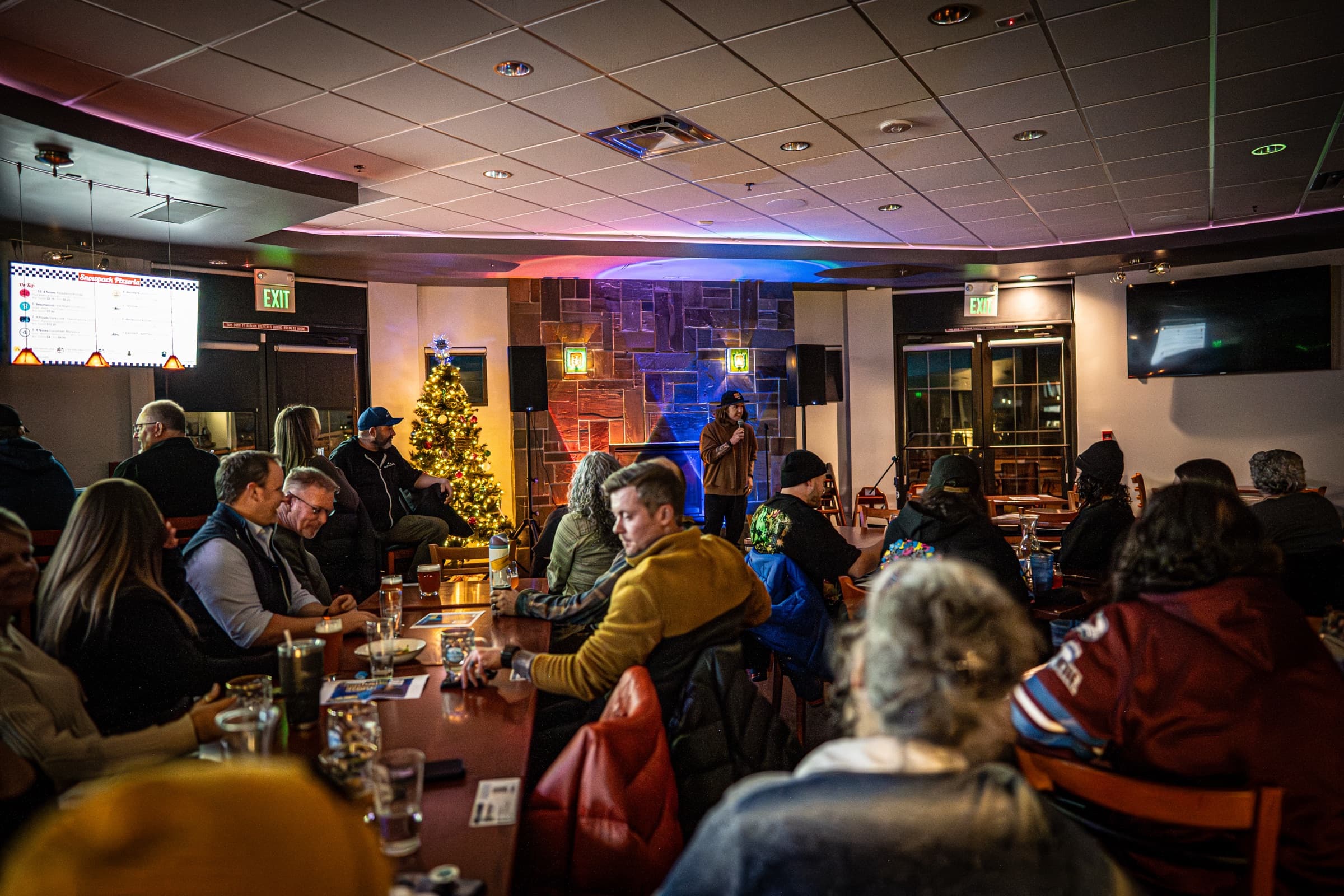 A live comedy night at Snowpack Taproom & Pizzeria in Conifer, Colorado — the kind of event the downstairs Pizzeria hosts